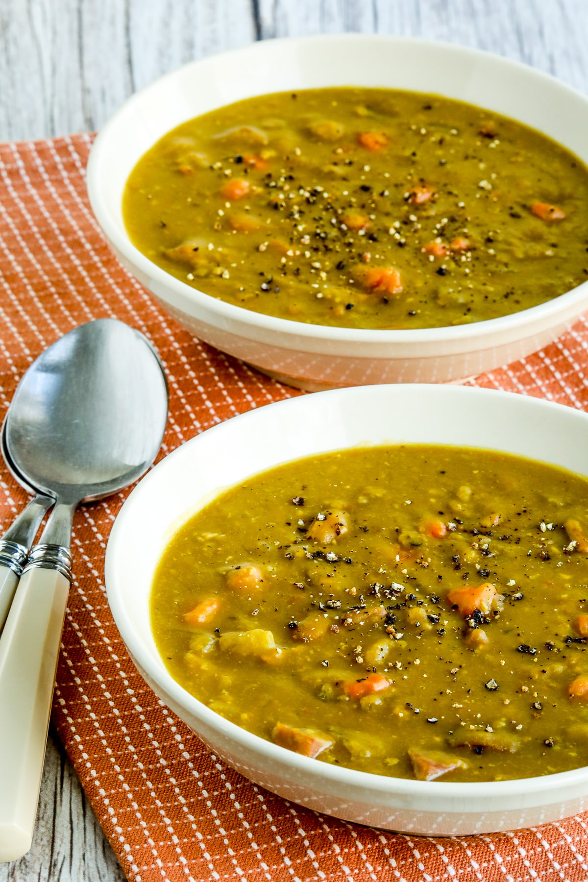 Slow Cooker Split Pea Soup with ham shown in two serving bowls.