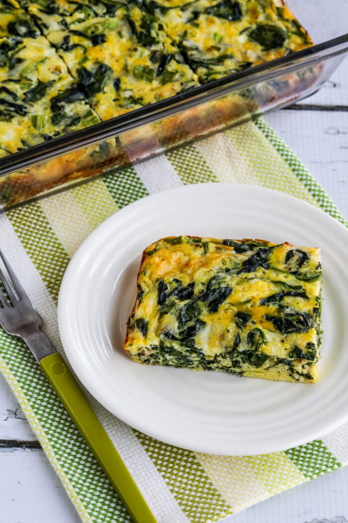 Spinach and Mozzarella Egg Bake one slice with rest of egg bake in casserole dish in background