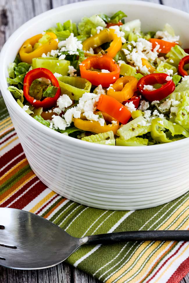 Peperoncini Chopped Salad with Romaine, Peppers, and Feta shown in salad bowl with serving spoon