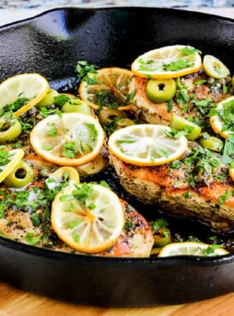 Chicken with Lemons, Green Olives, and Capers shown in cast-iron skillet