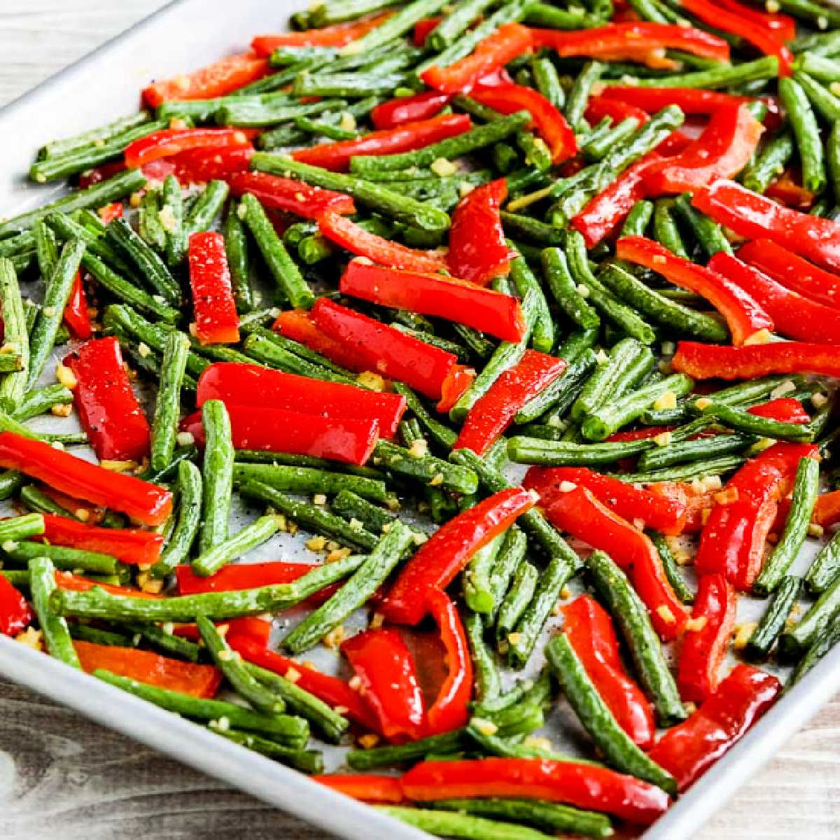 Square image of Roasted Green Beans and Red Peppers shown on baking sheet.