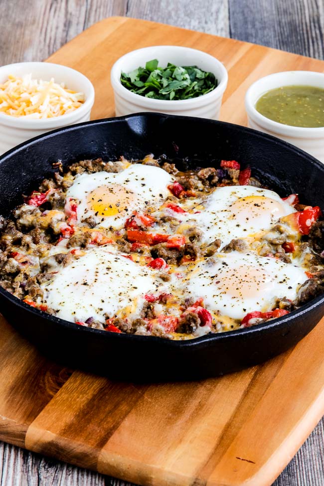 Southwestern Egg Skillet shown with salsa verde, cheese and cilantro in background
