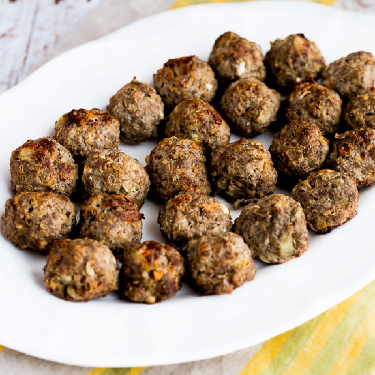 Square image for Baked Greek Meatballs with Feta shown on serving platter.