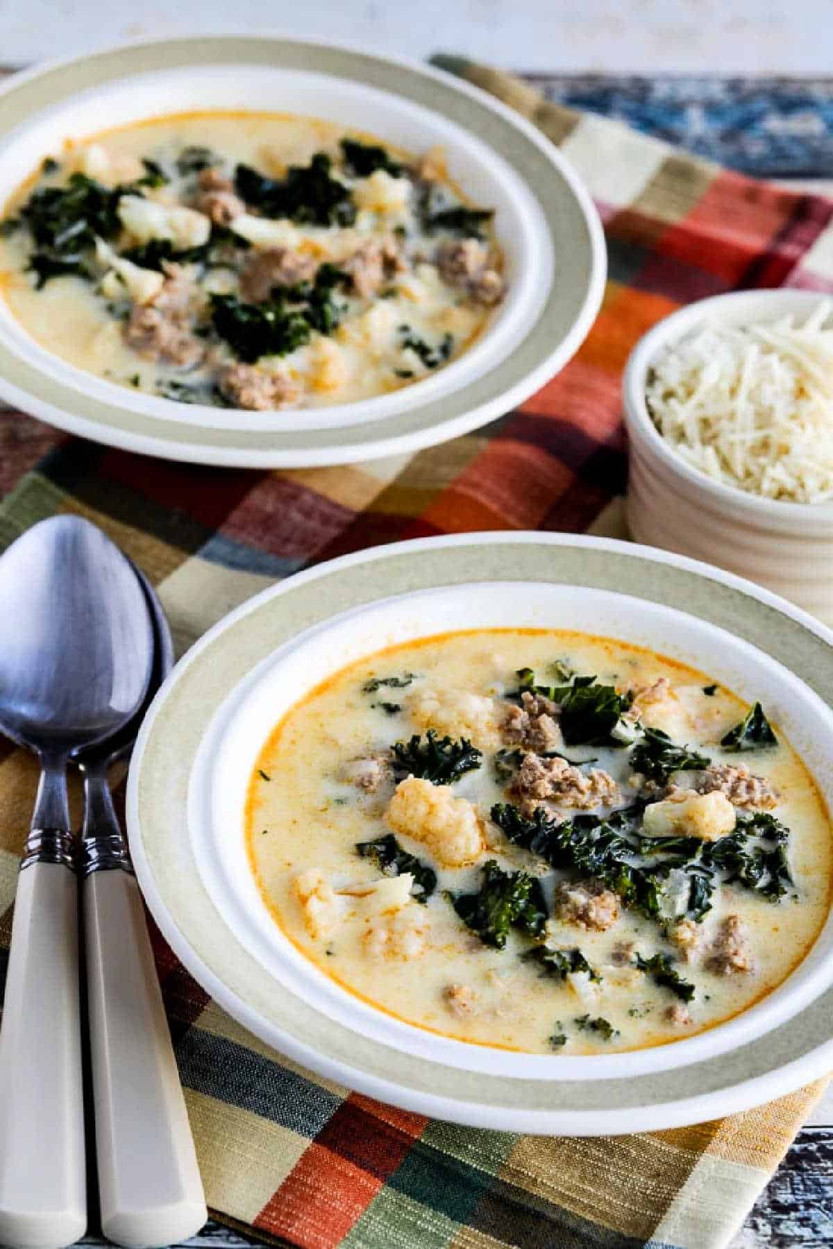 Instant Pot Zuppa Toscana Soup shown in two bowls with Parmesan