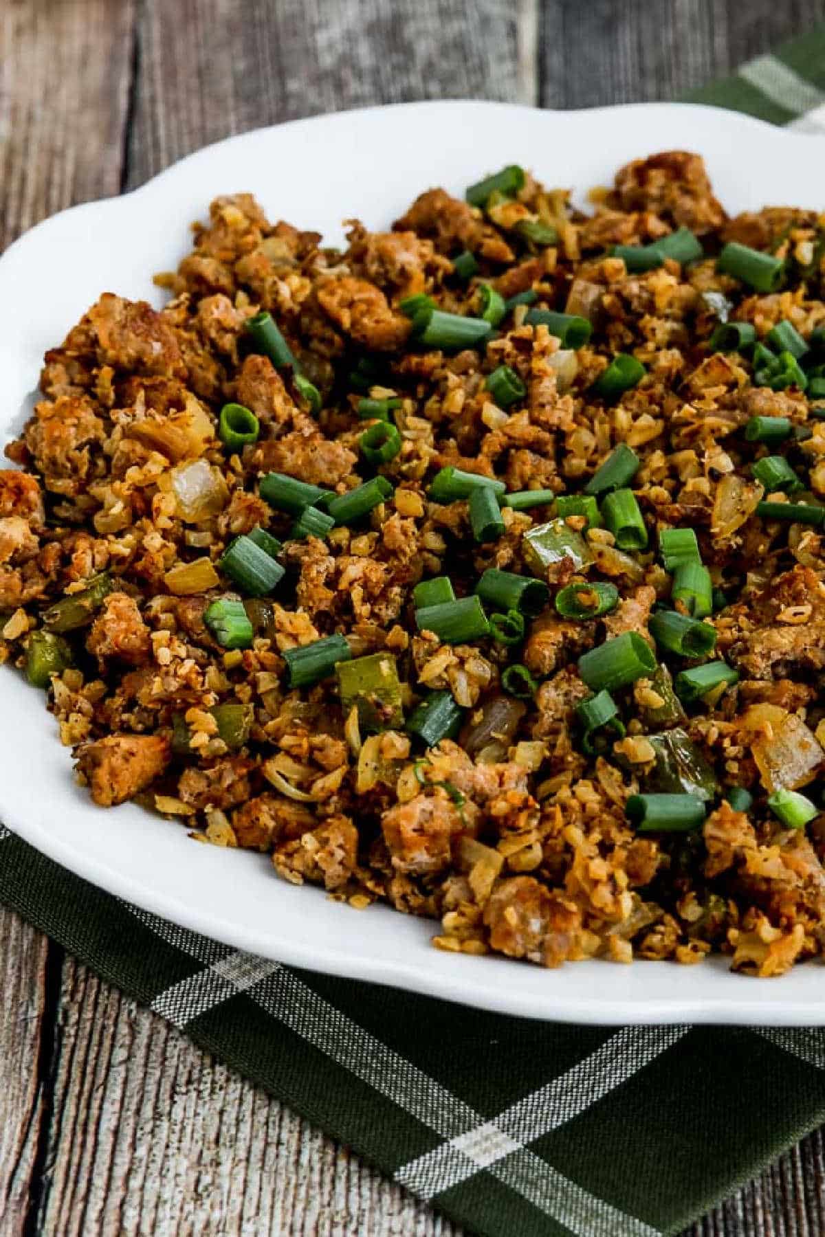 Low-Carb Spicy Cauliflower Dirty Rice in serving bowl on green napkin