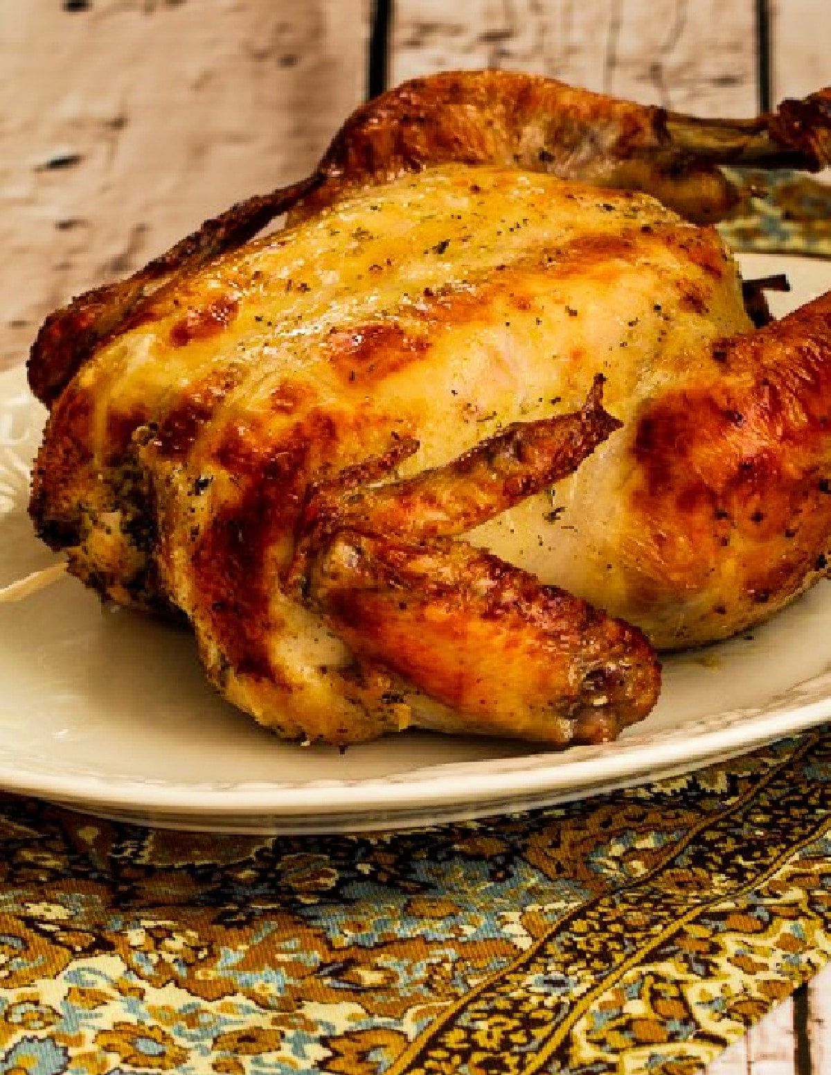 Greek Lemon Chicken showing whole chicken on platter, farther away