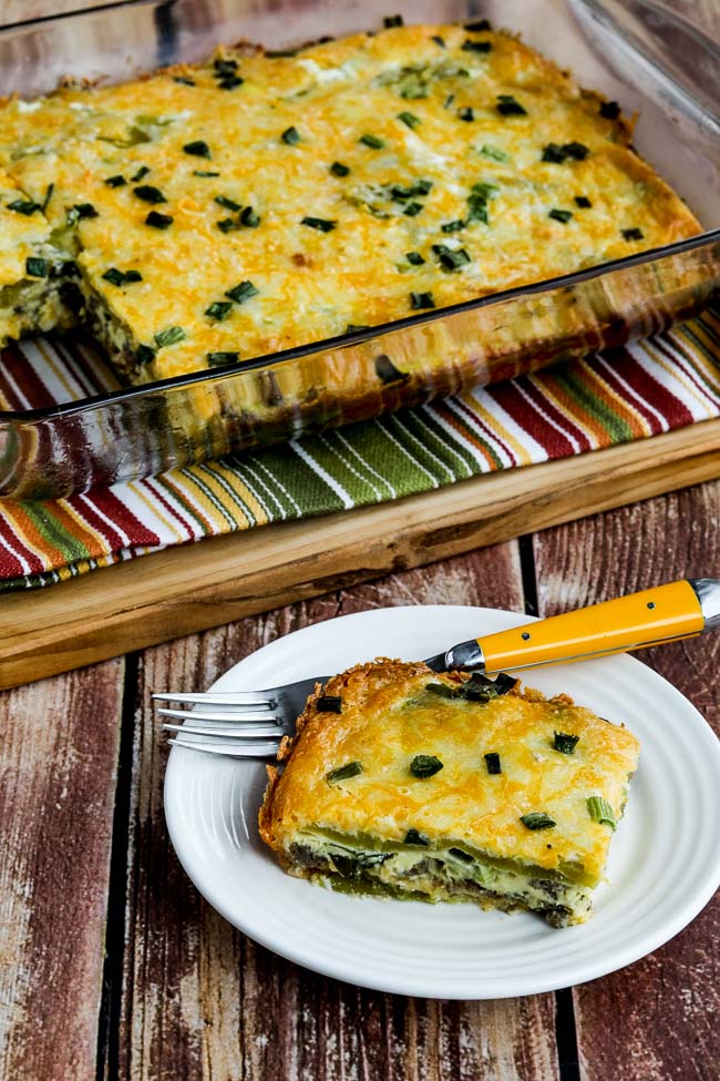 Cheesy Sausage and Green Chile Breakfast Casserole shown with one serving on plate and rest in baking dish.