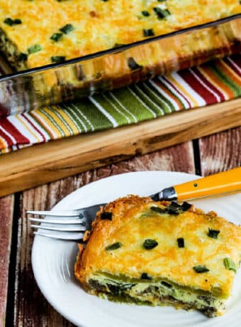 Green Chile Breakfast Casserole with one serving on plate and baking dish in back.