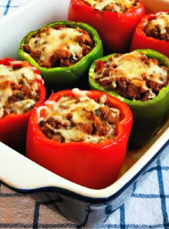 Large square image of Stuffed Peppers with Italian Sausage and Ground Beef shown in baking dish.