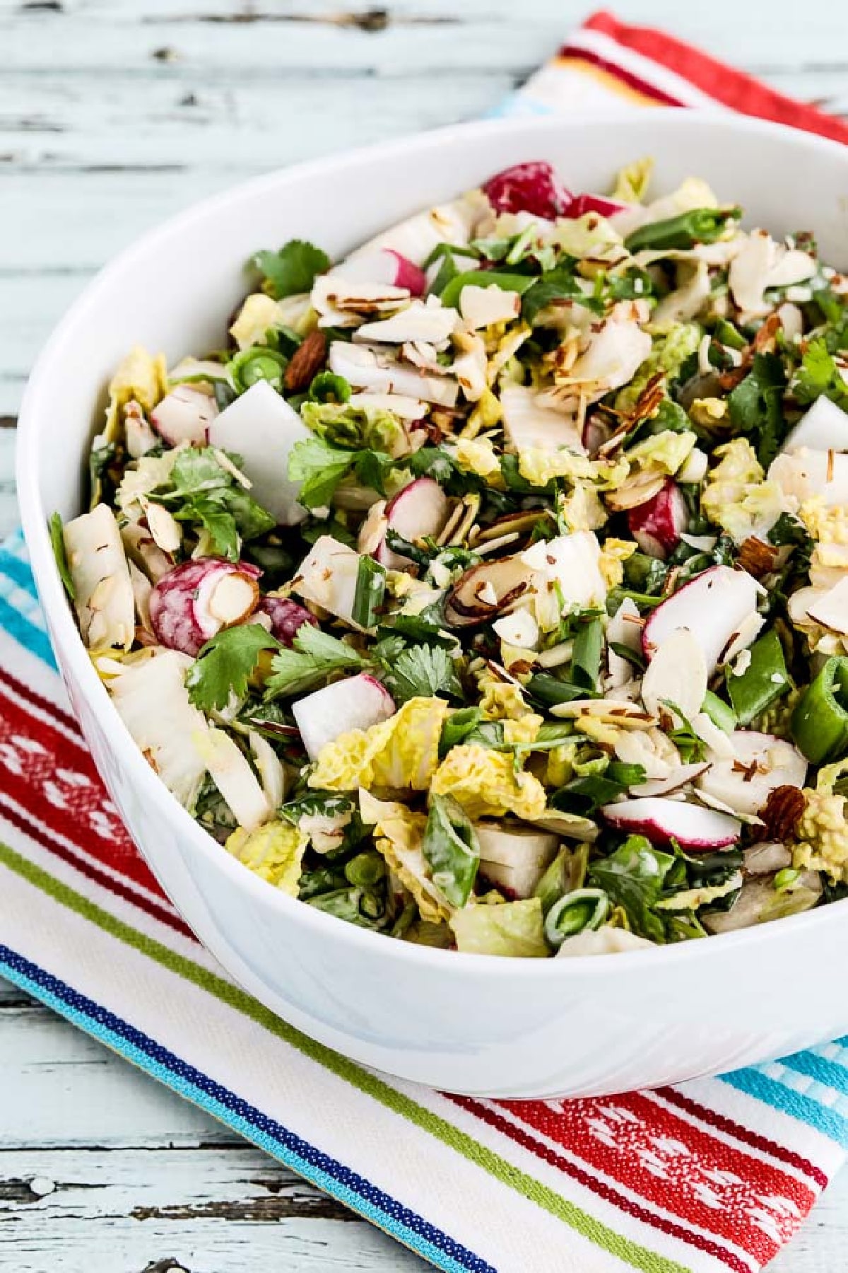 Napa Cabbage Asian Slaw in serving bowl on striped napkin