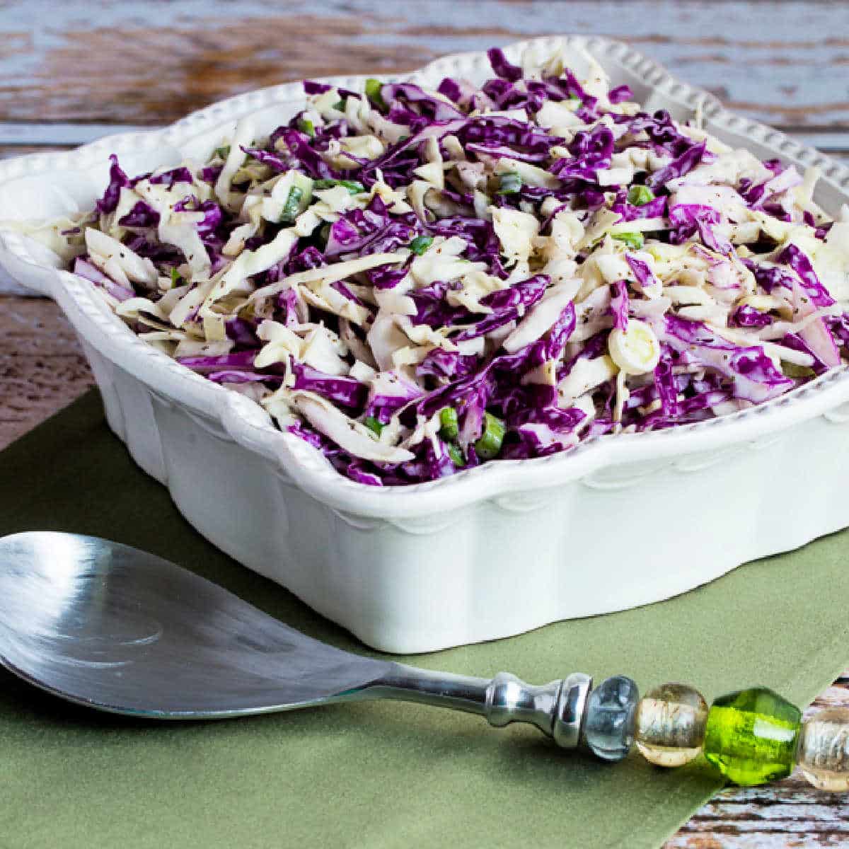 Square image for Blue Cheese Coleslaw in square serving dish on green napkin.