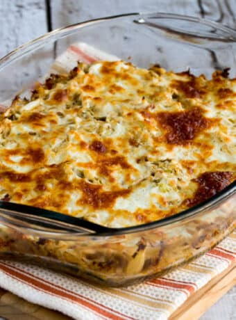 Twice-Cooked Cabbage with Sour Cream and Bacon shown in baking dish on striped towel on cutting board