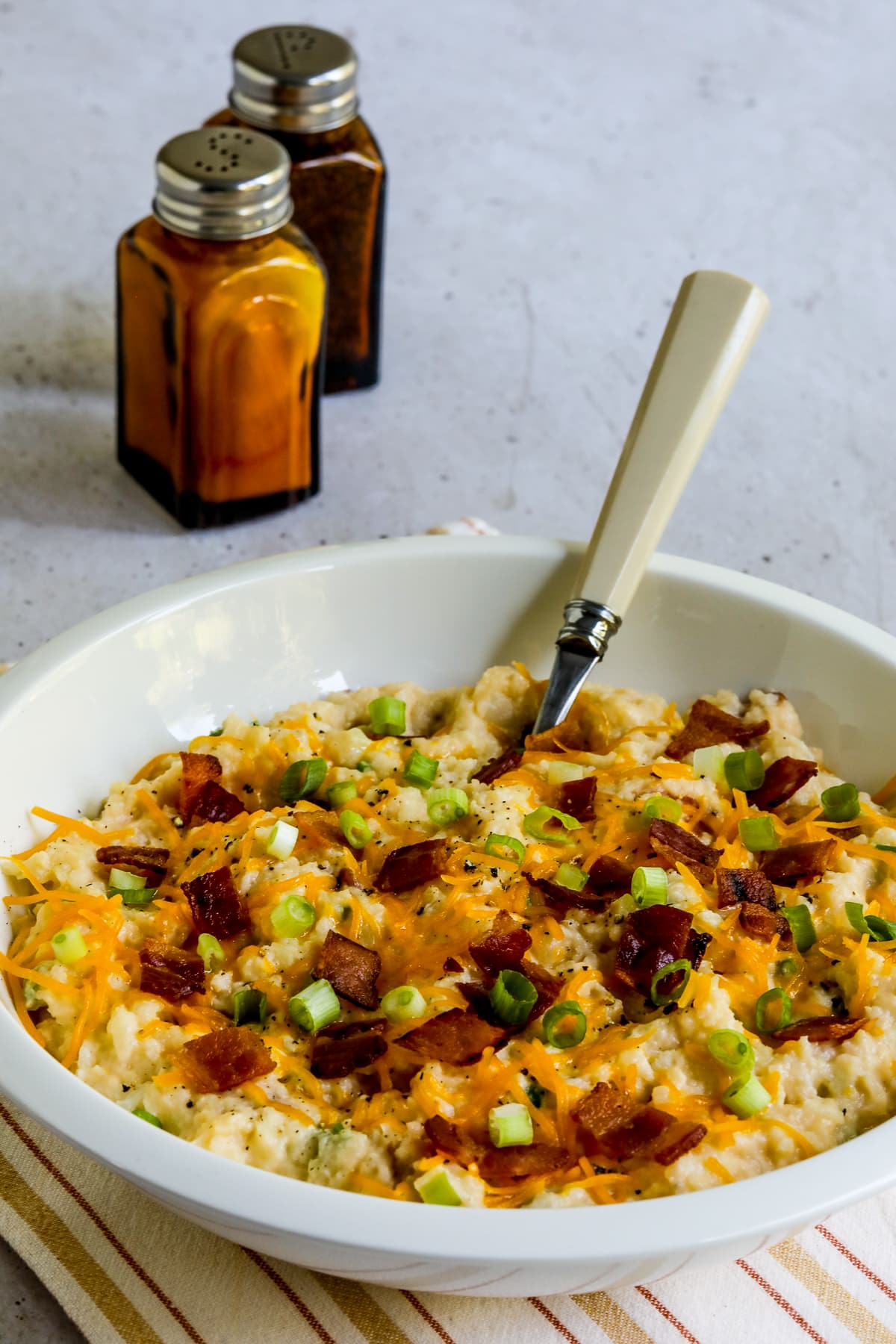 Loaded Cauliflower Mash (Instant Pot or Stovetop) in serving bowl with spoon.