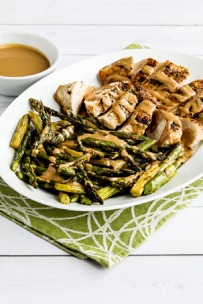 Chicken and Roasted Asparagus with Tahini Sauce on serving plate
