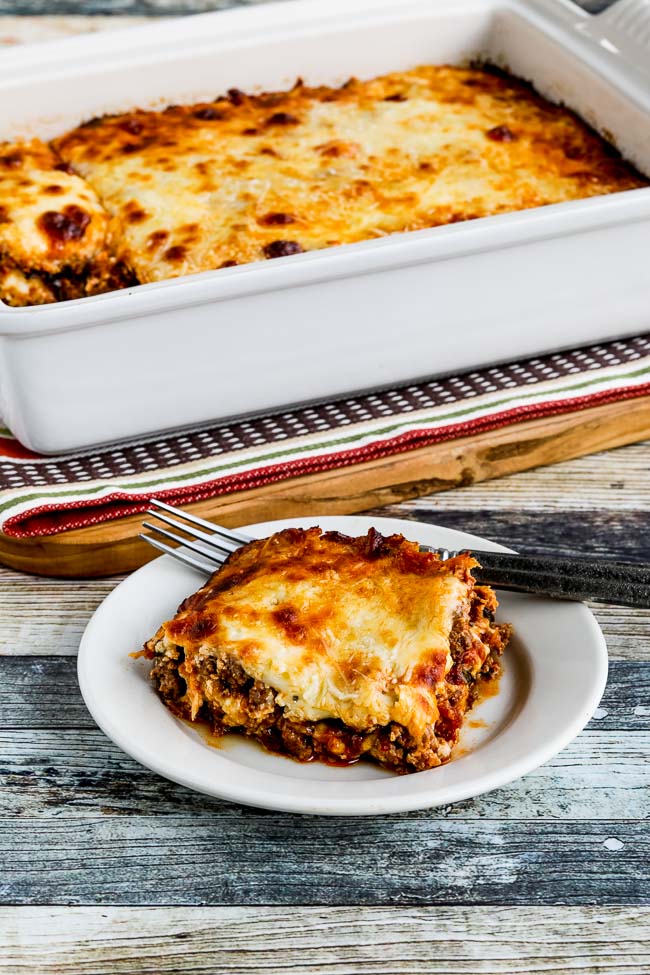 No-Noodle Lasagna with Sausage and Basil finished lasagna on serving dish with pan of lasagna in background