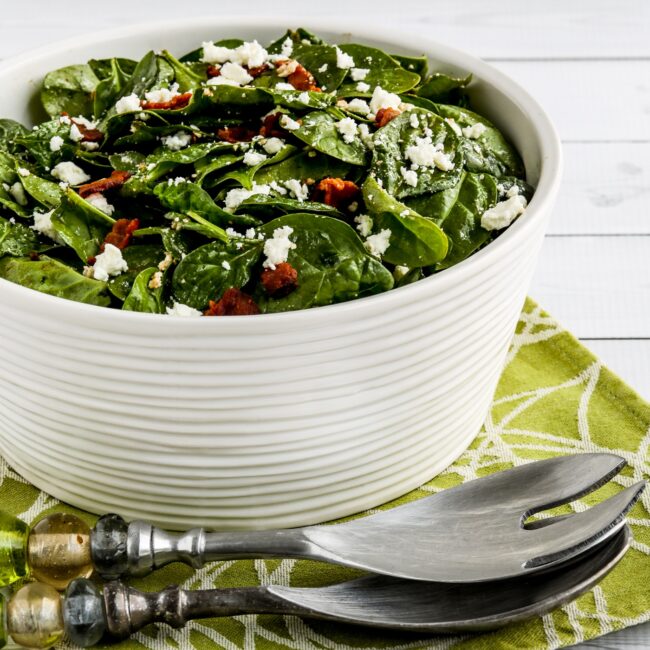 square image of Spinach Salad with Bacon and Feta in serving bowl with forks