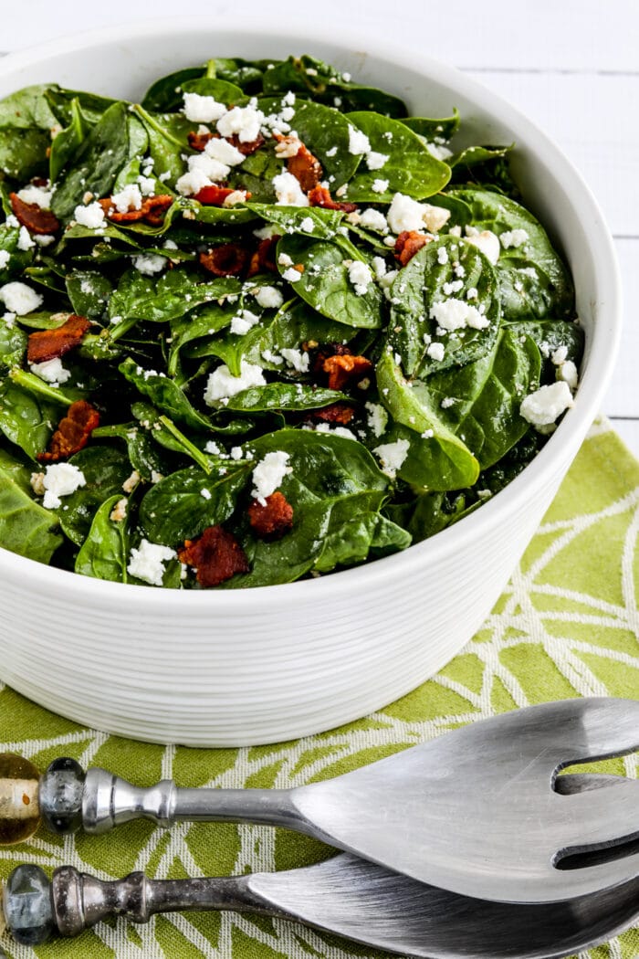 Spinach salad with bacon and feta in a serving dish with forks second photo