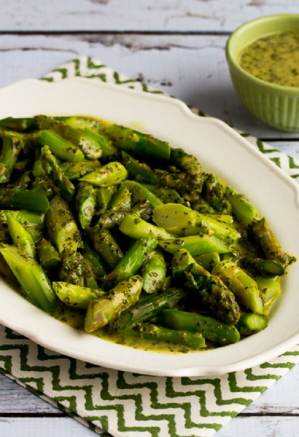 Asparagus with Basil Vinaigrette on serving plate with Basil Vinaigrette in background