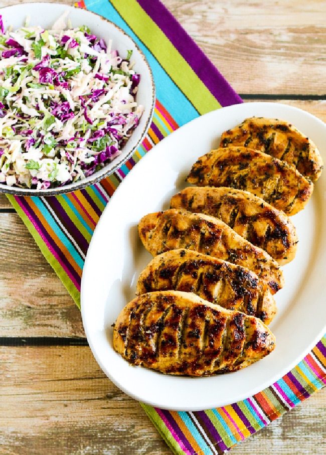 Garlic, Lemon, and Herb Grilled Chicken Breasts shown on serving plate with slaw in background