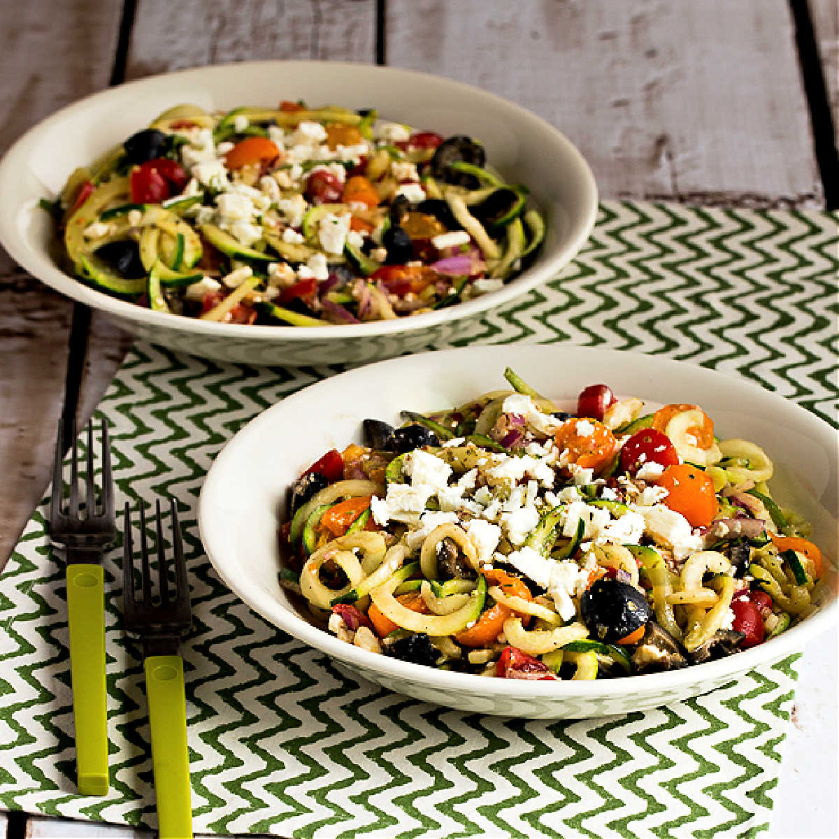 Greek zucchini noodles served in two bowls.