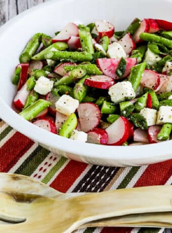 Square image for Asparagus and Radish Salad with Feta shown in serving bowl on striped napkin.