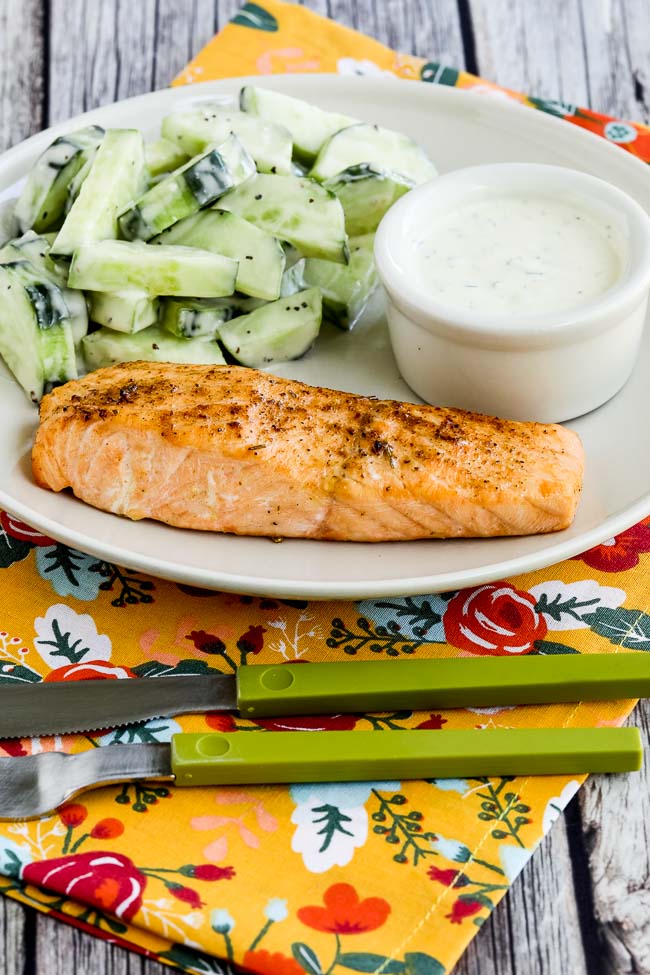 Air Fryer Salmon with Mustard-Herb Sauce finished salmon on serving plate with sauce and cucumber salad