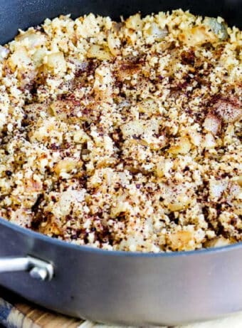 Square image of Spicy Cauliflower Rice sprinkled with Sumac, shown in pan.