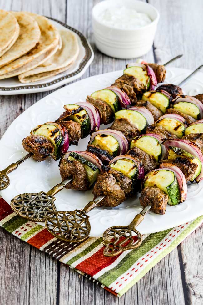 Low-Carb Lamb Shish Kabobs finished kabobs on serving plate with pita and Tzatziki sauce