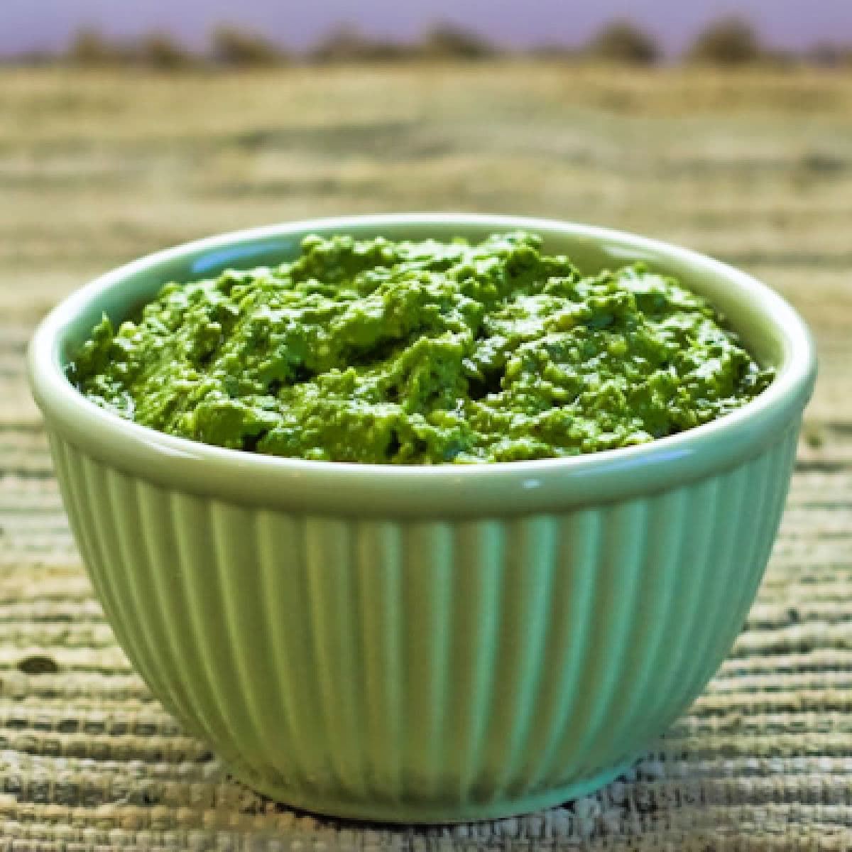 Close-up photo of Basil Pesto with Lemon in green bowl.