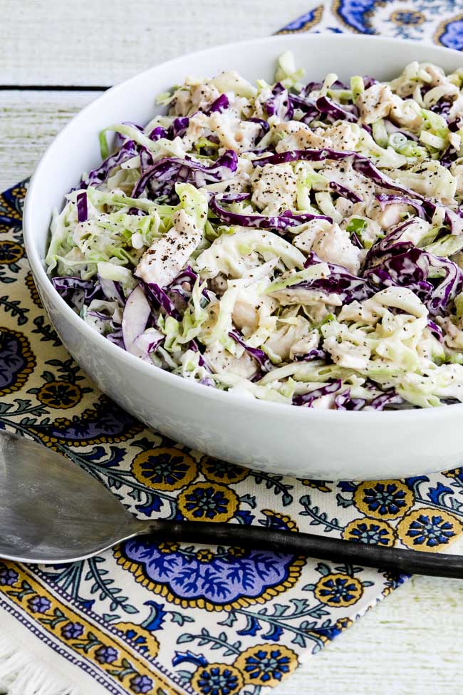 Chicken Cabbage Salad with Mustard shown in bowl on colorful napkin.