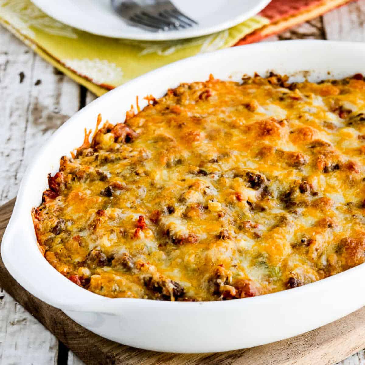 square image of Cheesy Low-Carb Taco Casserole in baking dish on napkin