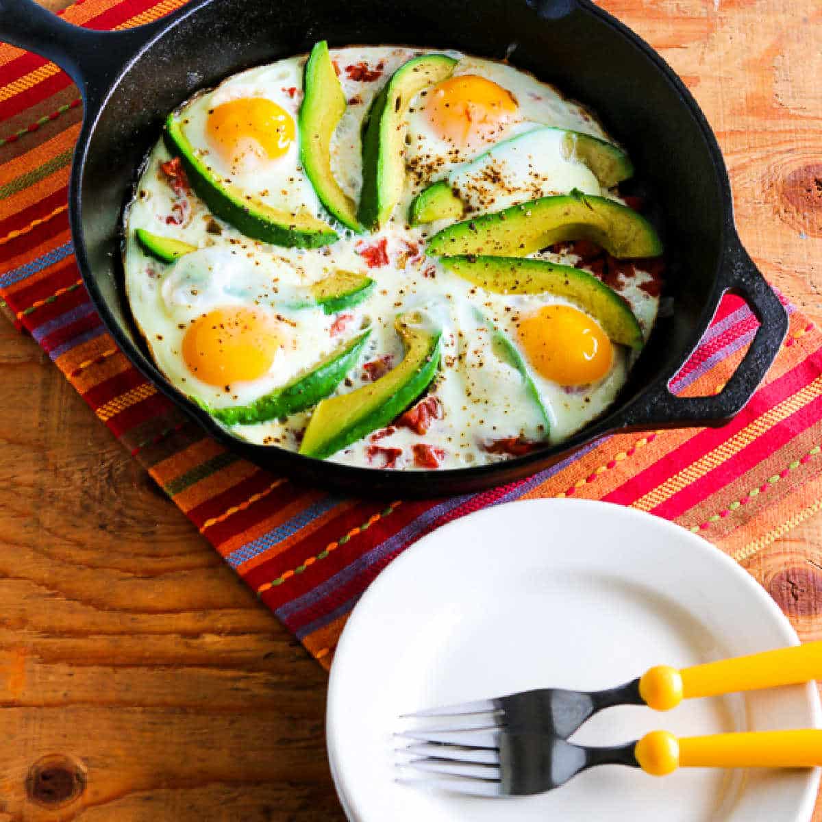 Egg Skillet with Avocado and Tomatoes shown in cast iron pan.