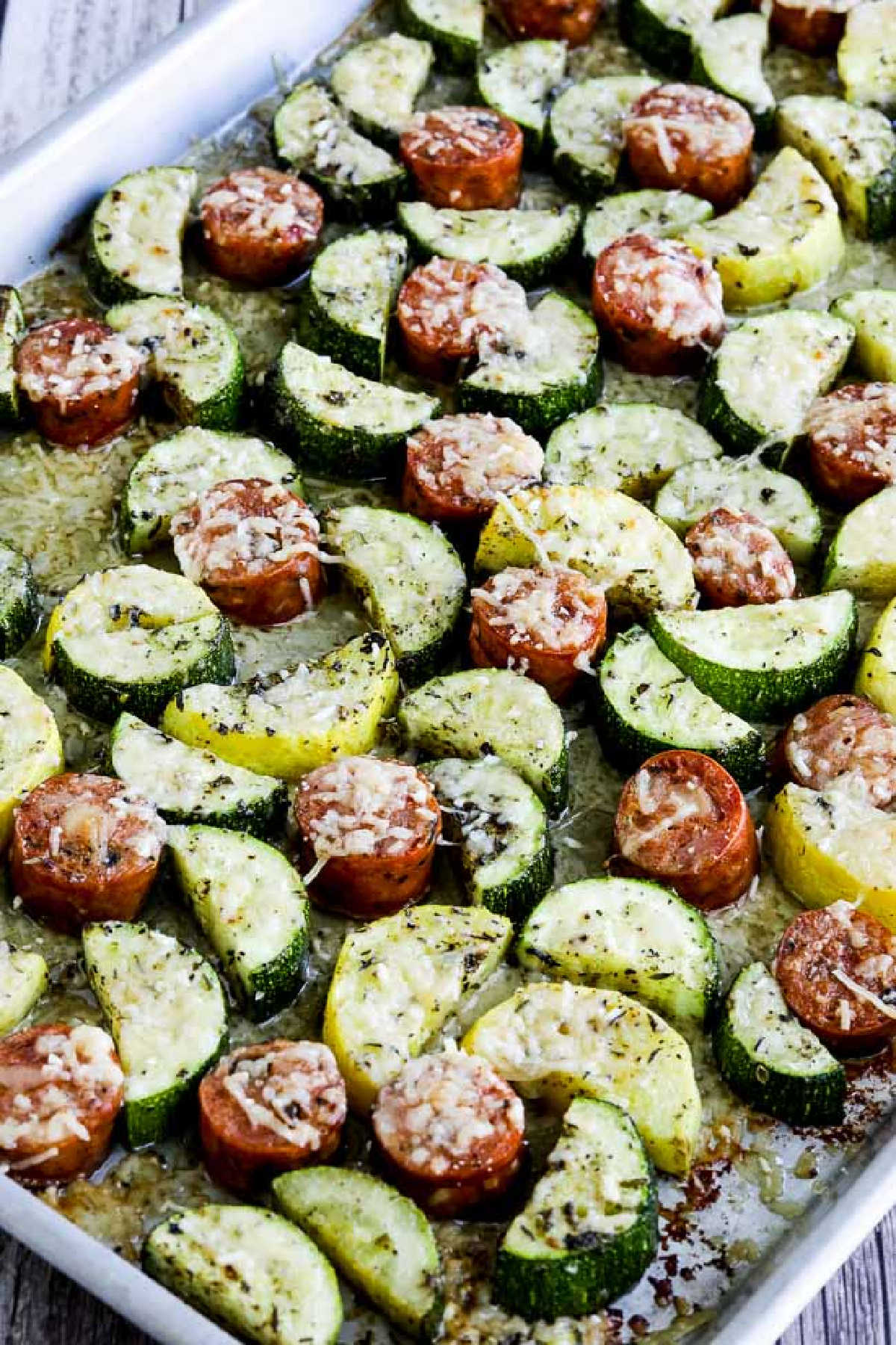 Cheesy Zucchini and Sausage Sheet Pan Meal shown on sheet pan with melted cheese