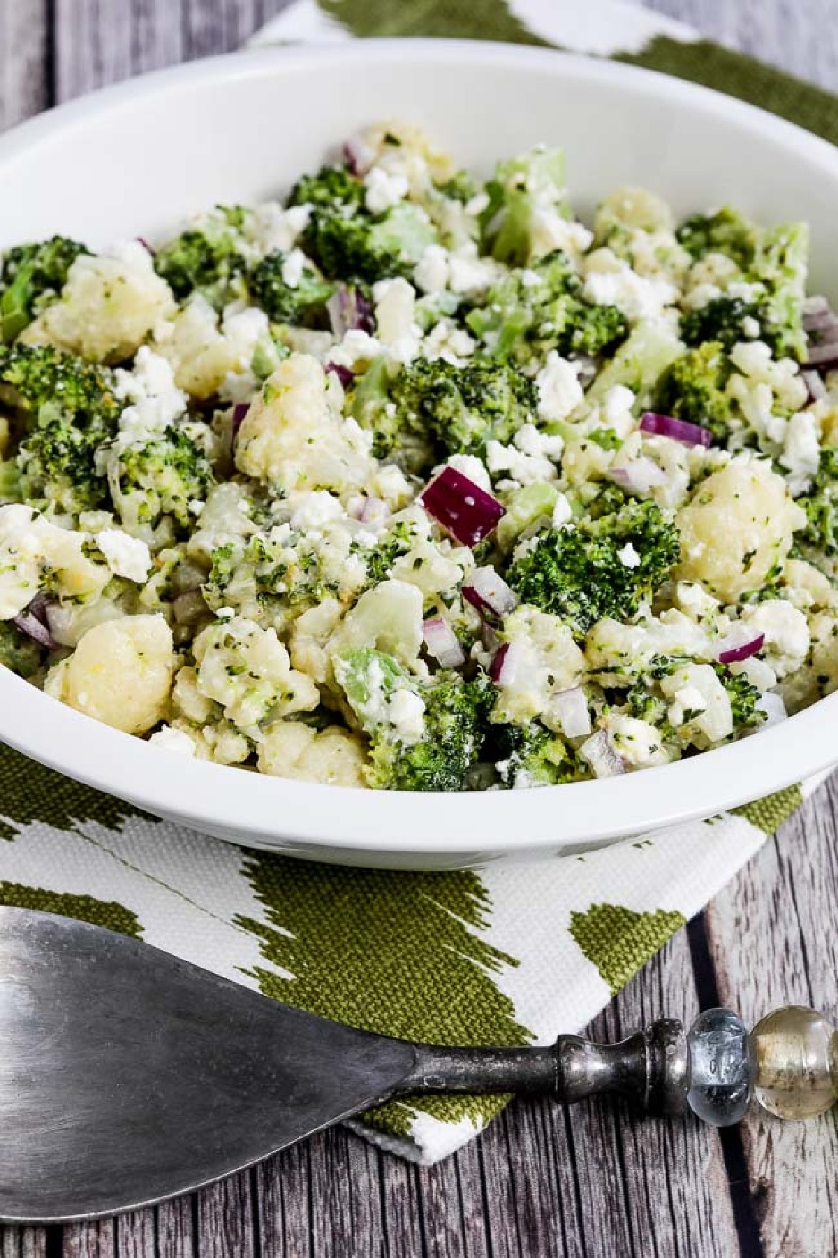 Broccoli and Cauliflower Salad with Feta in serving bowl on green-white napkin