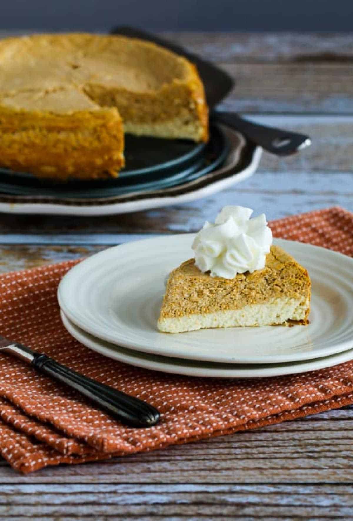 Sugar-Free Layered Pumpkin Cheesecake with one serving on small pan and rest of cheesecake in background