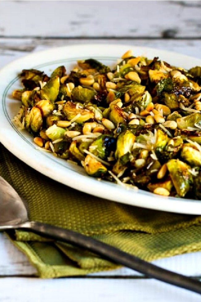 Roasted Brussels Sprouts with Balsamic, Parmesan, and Pine Nuts close-up photo of Brussels Sprouts on serving plate with spoon