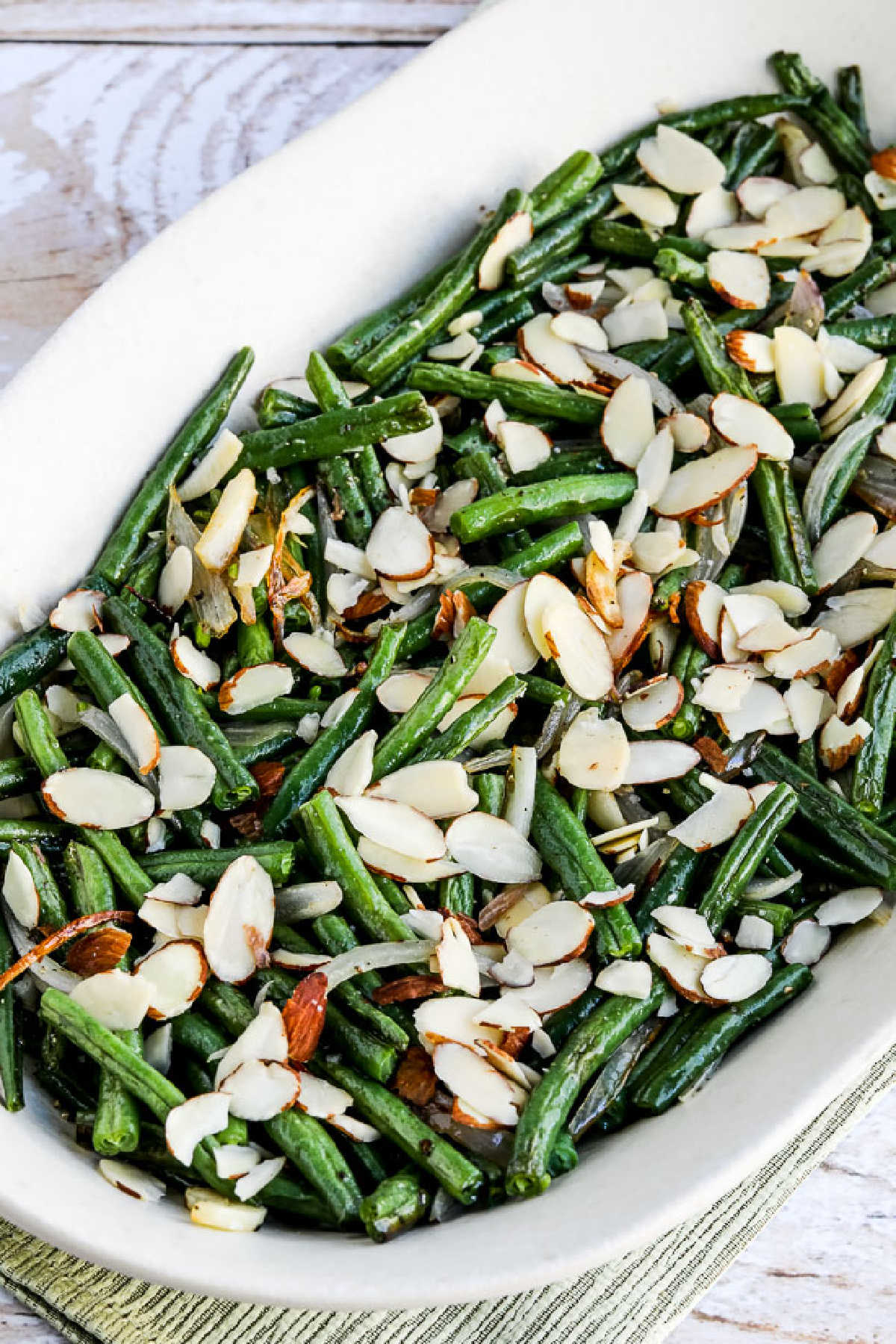 Garlic-Roasted Green Beans with Shallots and Almonds shown on serving platter, close-up image
