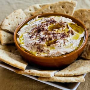 square image of Black-Eyed Pea Hummus in serving bowl with pita