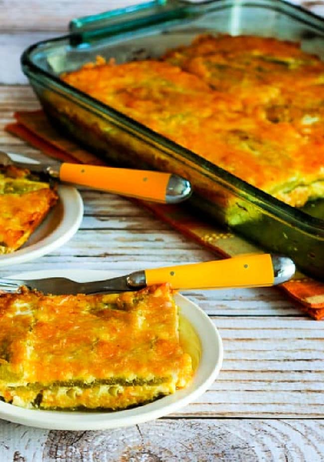 Cropped image of Chile Rellenos Bake with two servings on plates and casserole dish in back.