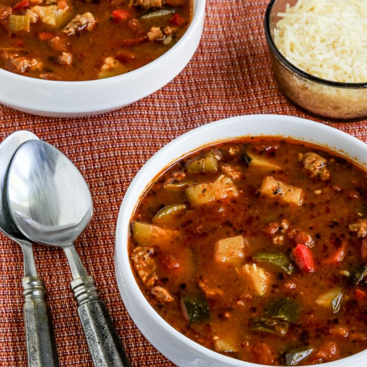 Italian Sausage Zucchini Soup shown in two bowls with optional Parmesan Cheese.