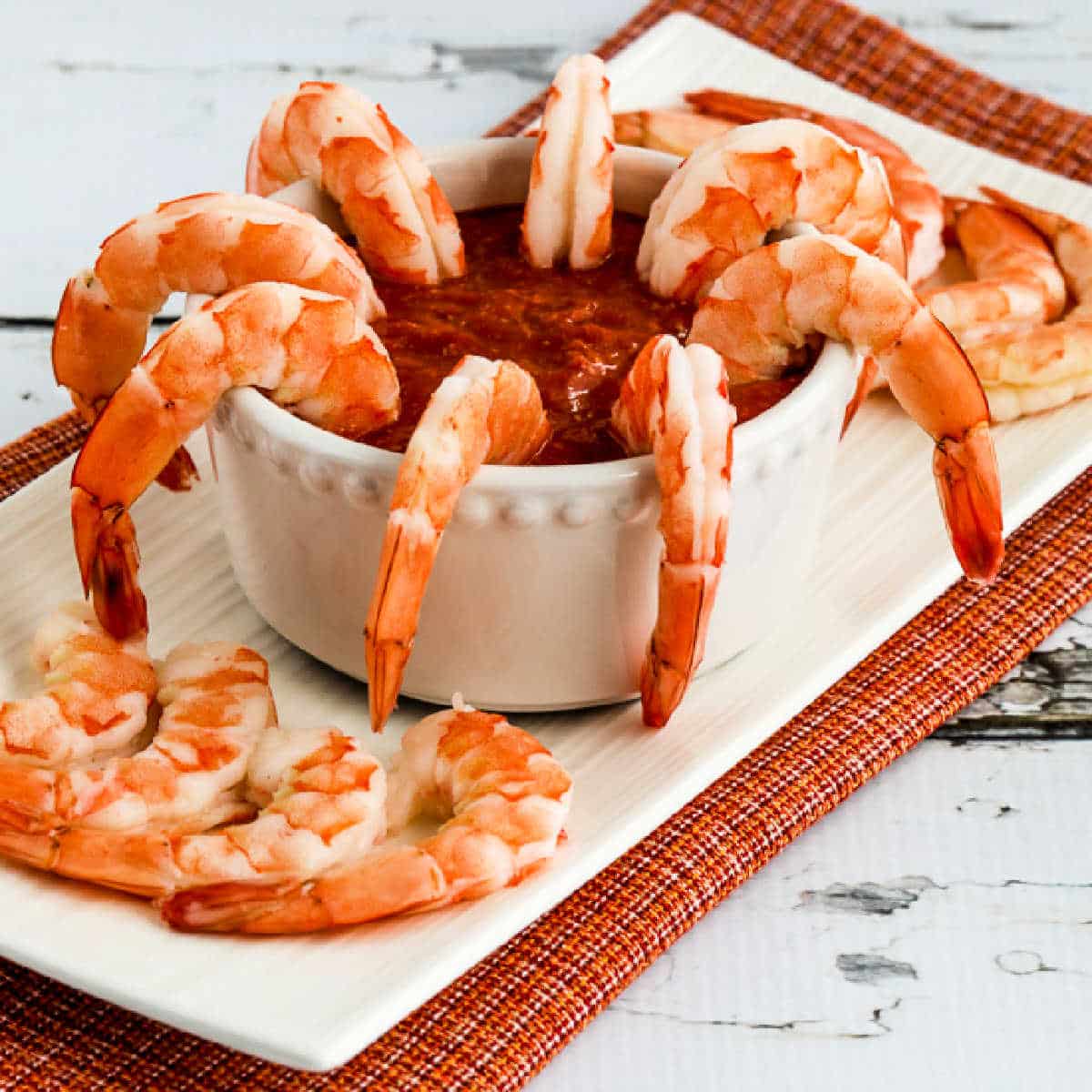 Shrimp with Keto Cocktail Sauce shown with shrimp in bowl of sauce and other shrimp on platter.