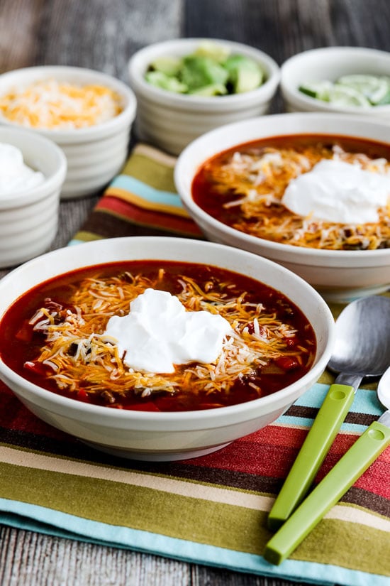 Instant Pot Taco Soup in two bowls with sour cream and cheese, close-up version