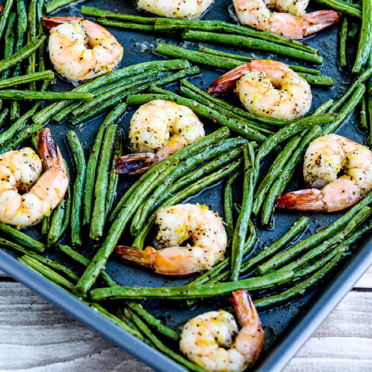 Square image for Spicy Green Beans and Shrimp Sheet Pan Meal shown on baking sheet.