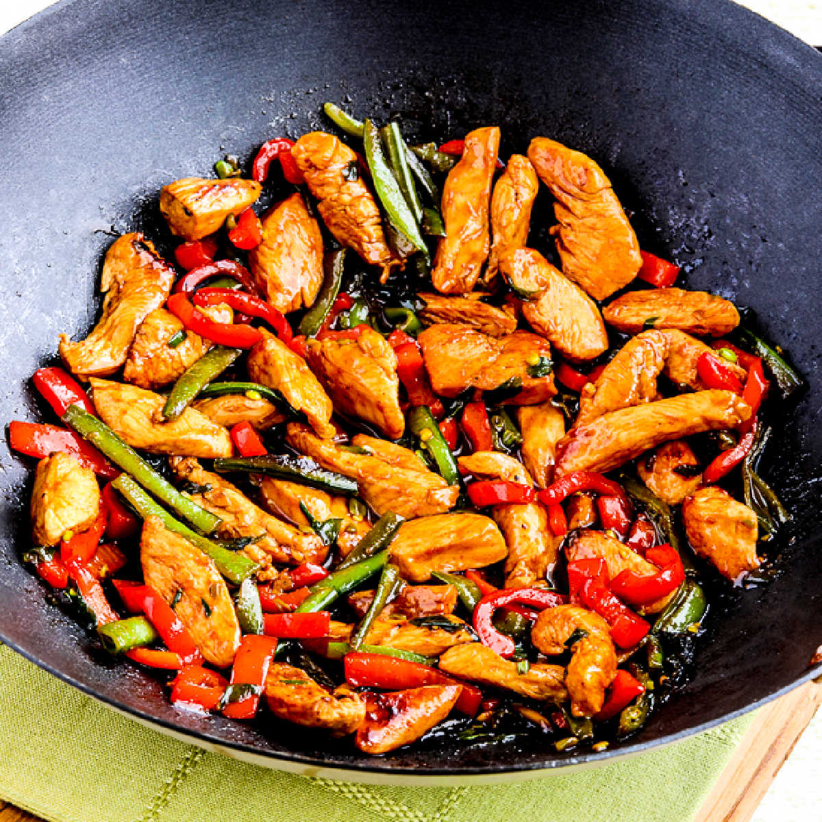 Square image for Ginger Chicken Stir Fry shown in wok, on napkin.