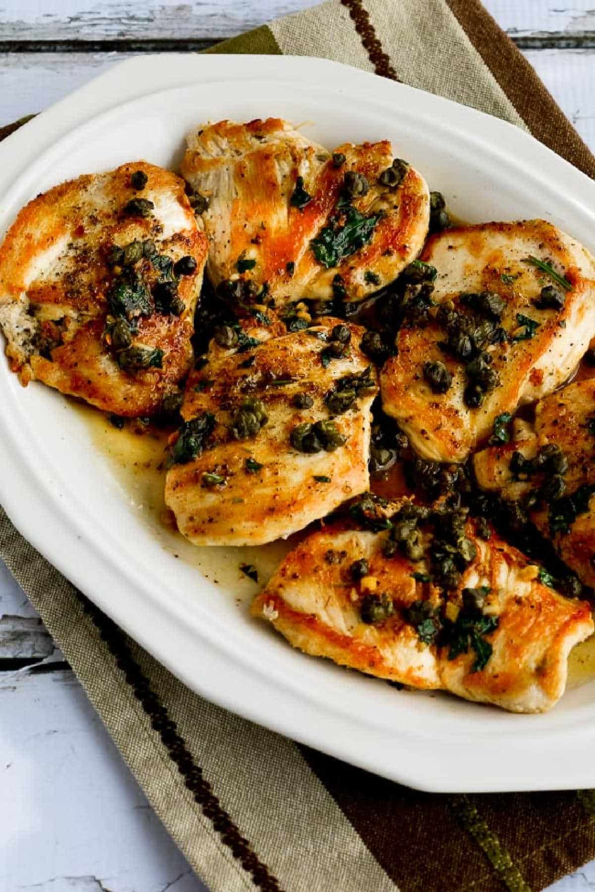 Chicken Piccata with Fried Capers on serving plate on napkin