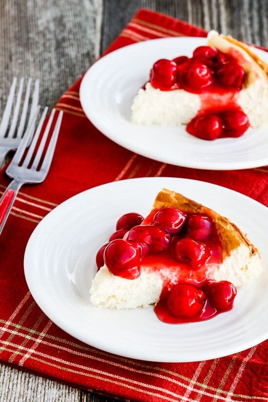 Low-Carb Cheesecake with Cherry Topping shown on two serving plates with forks.
