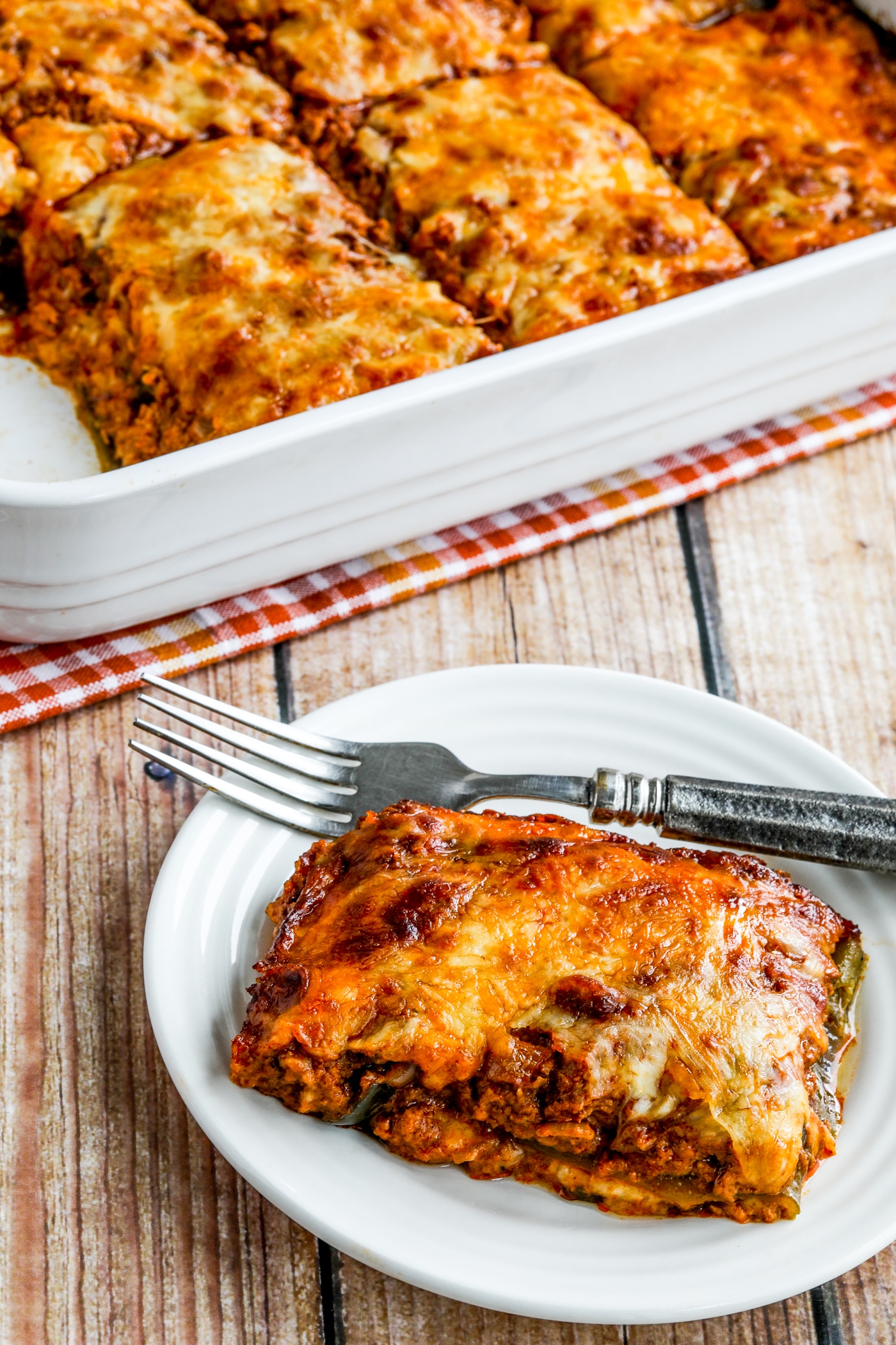 Low-Carb Turkey Enchilada Casserole one serving on plate and baking dish in background