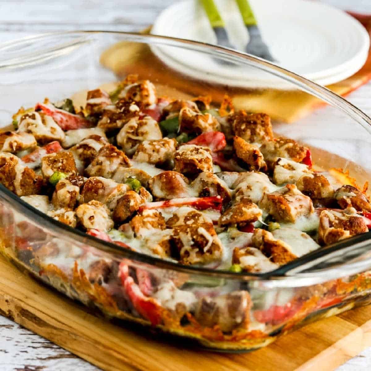 Square image of sausage, pepper and mushroom low carb cheese baked in a baking dish.