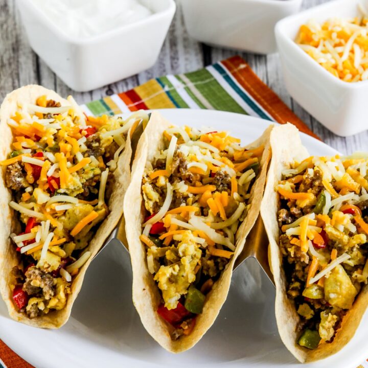 Low-Carb Breakfast Tacos Recipe shown with three tacos in holder on plate.
