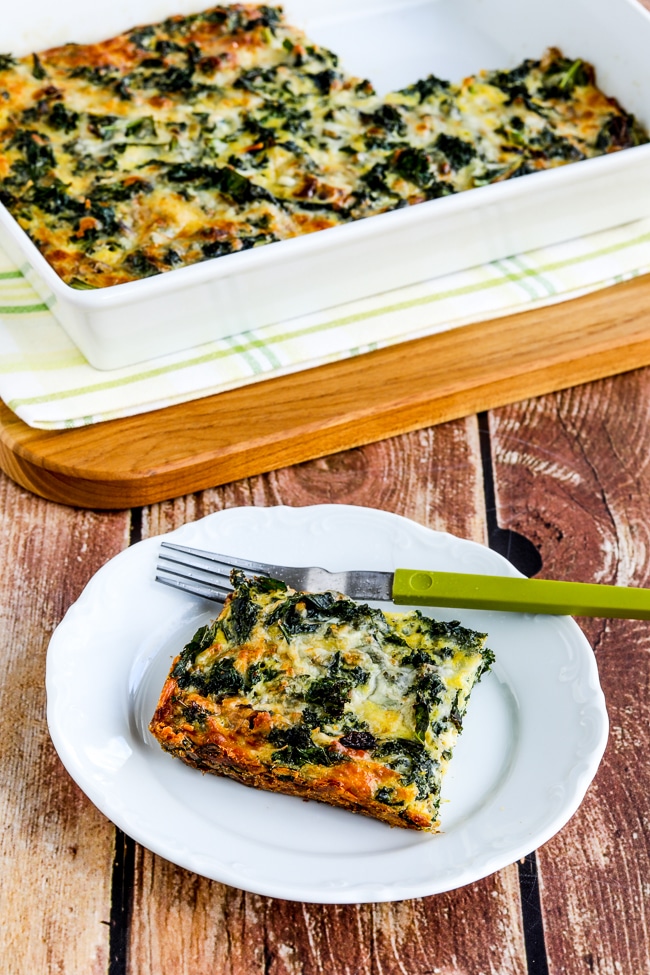 Kale and Red Onion Savory Breakfast shown in baking dish with one serving on plate in front.